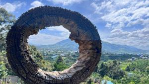 a large stone sculpture of a circle in the sky at Homestay Chân Quê in Bao Loc
