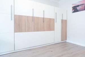 a room with white cabinets and wooden doors at Haus Schwanensee Studio 15 in Bosau