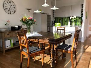 een keuken met een houten eettafel en stoelen bij Ferienwohnung Urlaubsglück- lichtdurchflutete Wohnung mit Balkon und Seesicht in Lindau