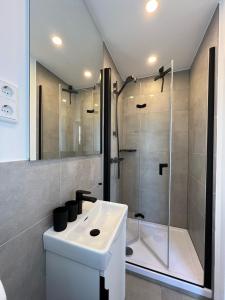 a bathroom with a white sink and a shower at Dünen Lodge 4 in Juist