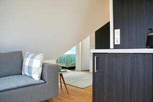 ein Wohnzimmer mit einem grauen Sofa und einer Treppe in der Unterkunft Strandhaus Rose in Juist