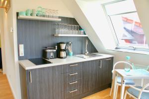 a kitchen with a counter with a sink and a window at Strandhaus Rose in Juist