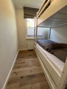 a bedroom with a bunk bed and a window at Dünen Lodge 1 in Juist