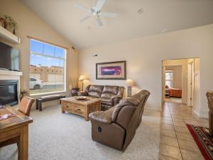 a living room with a couch and a tv at Rim Village X3 - large patio with private hot tub in Moab