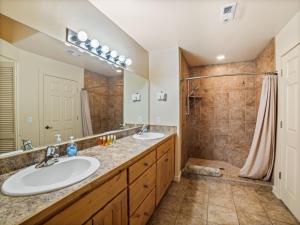 a bathroom with two sinks and a shower at Rim Village X3 - large patio with private hot tub in Moab +24 photos