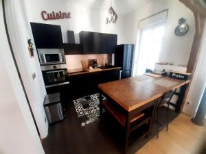 a kitchen with a wooden table and a kitchen with a stove at Maison de ville au centre de Fismes in Fismes