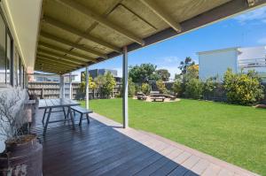 a porch with a picnic table and a lawn at Ocean Spray Retreat in Port Fairy