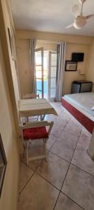 Zimmer mit 2 Betten und einem Tisch in der Unterkunft Suítes Praia Do Foguete in Cabo Frio