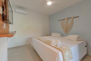 a bedroom with a bed with two slippers on it at Pousada Katavento #Q2 - Suíte Dupla por Carpediem in Cumbuco