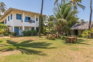 a house with tables and chairs in the yard at Pousada Katavento #Q2 - Suíte Dupla por Carpediem in Cumbuco