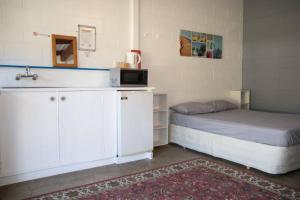 a small room with a bed and a microwave at Russell-Orongo Bay Holiday Park in Russell