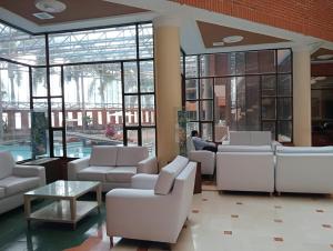 伊瓦格的住宿－莫拉萊斯國際酒店及會議中心，大堂设有白色的沙发,还有人坐在里面