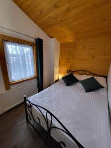 1 dormitorio con 1 cama con techo de madera en Stroński Domek en Stronie Śląskie