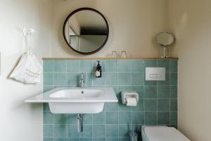 uma casa de banho com um lavatório, um WC e um espelho. em La Loge Gogaille - 7 Dormants - Accès autonome em Orléans