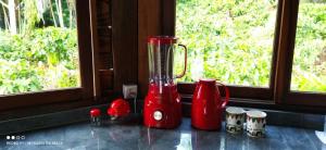a red blender sitting on a counter next to a window at Moradia da Mata in Nilo Peçanha
