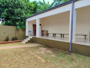 ein Gebäude mit einer Veranda mit Bänken darauf in der Unterkunft Villa Candida in Encarnación