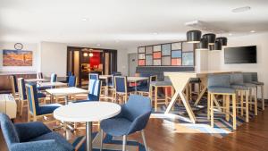 a restaurant with blue chairs and tables at Hampton Inn Phoenix Airport North in Phoenix