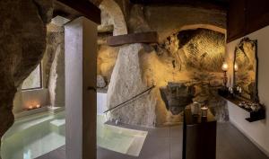 uma casa de banho com uma banheira numa parede de pedra em Dimora d'Arte Mariano Pietrini em Barcellona Pozzo di Gotto