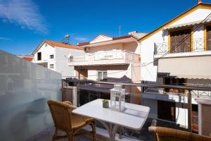 a white table and chairs on a balcony at Kentrikon Rooms in Limenaria
