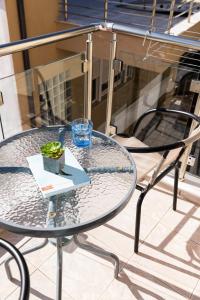 una mesa de cristal y sillas en un patio en Kentrikon Rooms en Limenaria