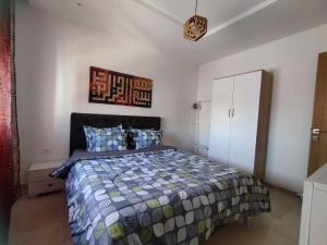 a bedroom with a bed and a clock on the wall at Luxueux S1 Mourouj 6 in Nassene Srhira
