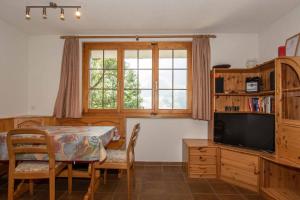 a dining room with a table and a television at Ferienwohnung Senggi in Adelboden