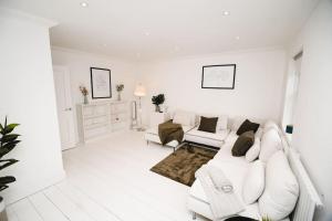 a white living room with a white couch and chairs at Brand New Stylish Three Story House! in Thorpe Saint Andrew