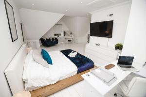 Brand New Stylish Three Story House! في Thorpe Saint Andrew: غرفة نوم بيضاء كبيرة مع سرير كبير وتلفزيون