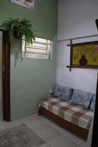 a bedroom with a bed and a window and a plant at Recanto do Sossego in Caraguatatuba