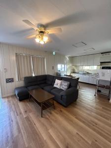 a living room with a couch and a ceiling fan at ライフタイムハウス55 in Furugen