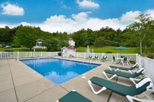 a swimming pool with chaises and chairs next to a fence at Best Western - Freeport Inn in Freeport