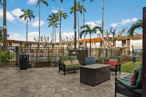 檀香山的住宿－Best Western The Plaza Hotel - Free Breakfast，一个带椅子的庭院和种有棕榈树的烧烤架