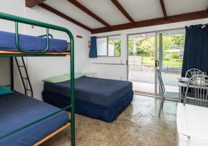 two bunk beds in a room with a balcony at Russell-Orongo Bay Holiday Park in Russell