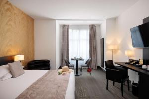une chambre d'hôtel avec un lit, une table et des chaises dans l'établissement Best Western Plus Hôtel Massena Nice, à Nice
