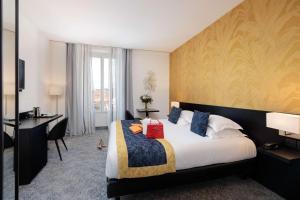 a hotel room with a large bed and a desk at Best Western Plus Hôtel Massena Nice in Nice
