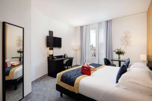 a hotel room with a large bed and a mirror at Best Western Plus Hôtel Massena Nice in Nice