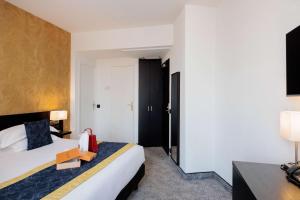 a hotel room with two beds and a television at Best Western Plus Hôtel Massena Nice in Nice