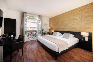 a hotel room with a bed and a desk and a window at Best Western Plus Hôtel Massena Nice in Nice