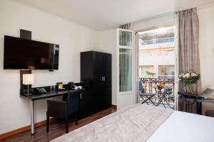 a hotel room with a bed and a desk and a window at Best Western Plus Hôtel Massena Nice in Nice