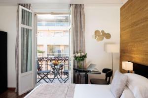a bedroom with a bed and a balcony with a desk at Best Western Plus Hôtel Massena Nice in Nice