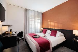 a hotel room with a large bed and a desk at Best Western Plus Hôtel Massena Nice in Nice