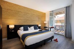 a bedroom with a large bed and a balcony at Best Western Plus Hôtel Massena Nice in Nice