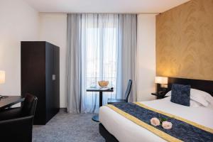 a hotel room with a bed and a desk and a window at Best Western Plus Hôtel Massena Nice in Nice