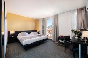 a hotel room with a bed and a desk at Best Western Plus Hôtel Massena Nice in Nice