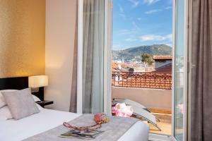 a bedroom with a bed and a view of a balcony at Best Western Plus Hôtel Massena Nice in Nice