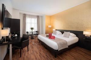 a hotel room with a bed and a desk at Best Western Plus Hôtel Massena Nice in Nice