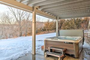 uma banheira de hidromassagem sentada sob uma cobertura com um pátio coberto de neve em The Craftsman, large & boutique Galena retreat em Galena