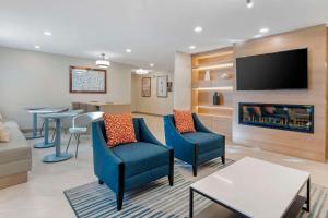 a living room with blue chairs and a fireplace at Comfort Inn Marina on the Monterey Bay in Marina