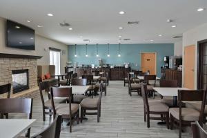a restaurant with tables and chairs and a fireplace at Sleep Inn & Suites Washington near Peoria in Washington