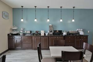 a kitchen with brown cabinets and a blue wall at Sleep Inn & Suites Washington near Peoria in Washington